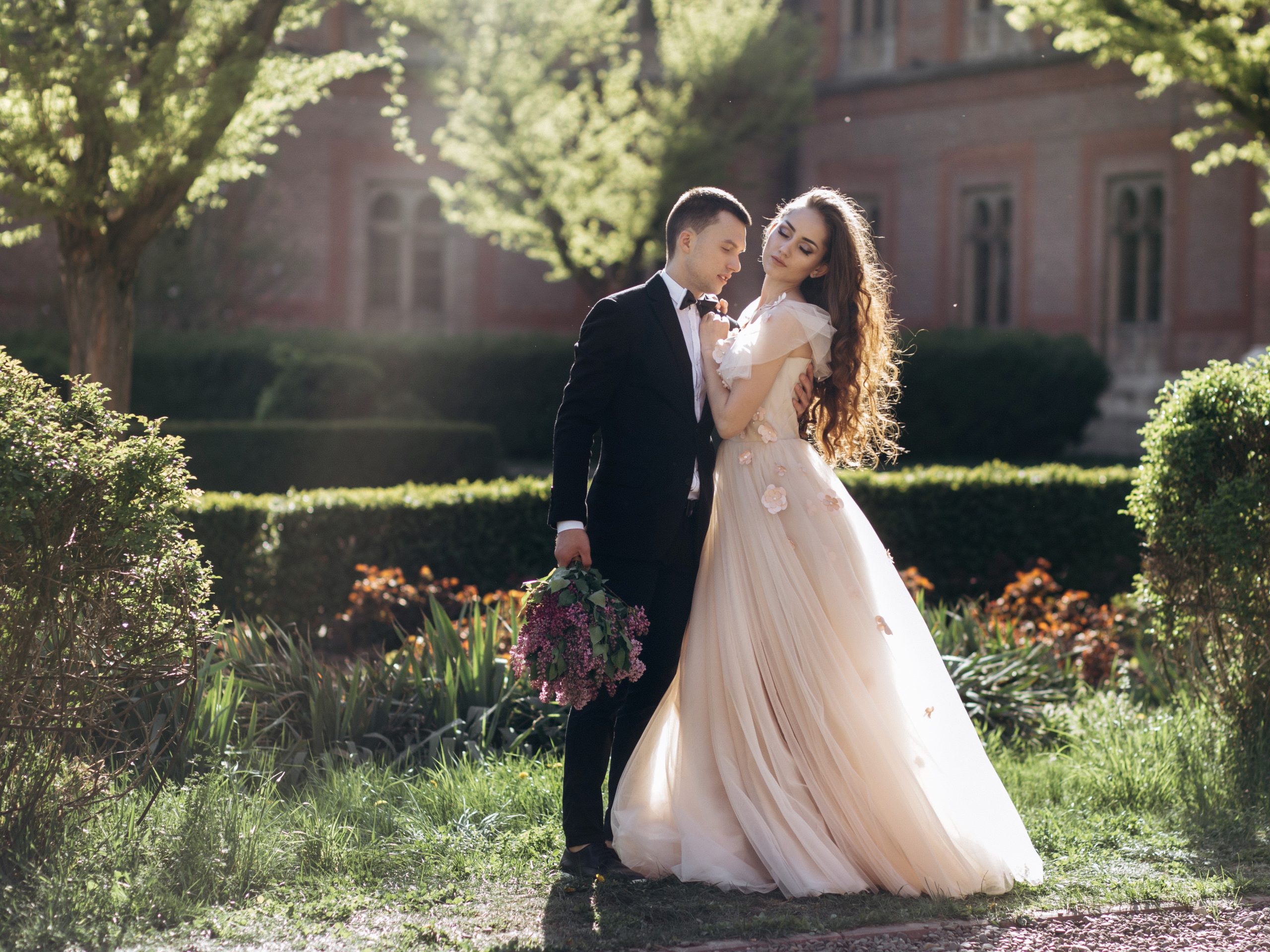 The bride and groom embracing in the park
